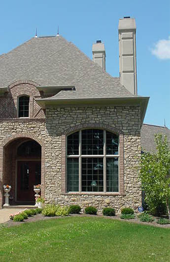 Side photo of a Michael and associates custom home with stone and brick work