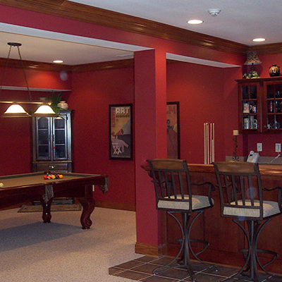 Red entertainment space with built-in bar designed by Michael and Associates