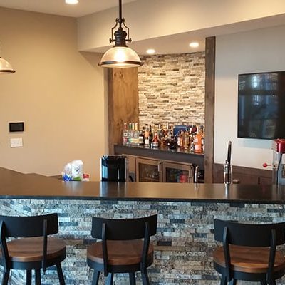 Custom home entertainment bar with tile, slate bar top and hanging lights