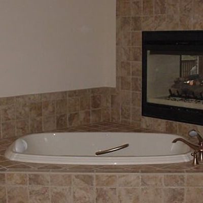 Michael and associates custom bathroom with large feature bath tub with feature fireplace
