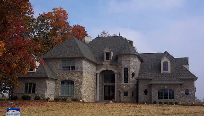 Michael and associates custom home with large rounded feature with custom brick and stone