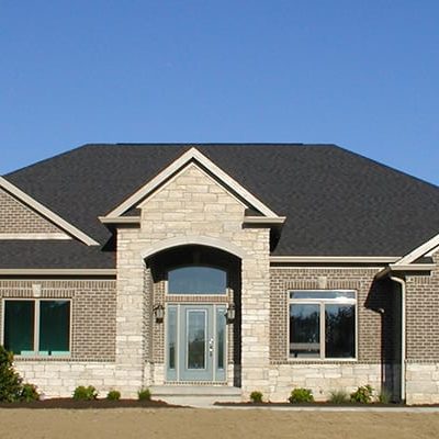 Exterior of custom ranch home with brown and grey stone and brick
