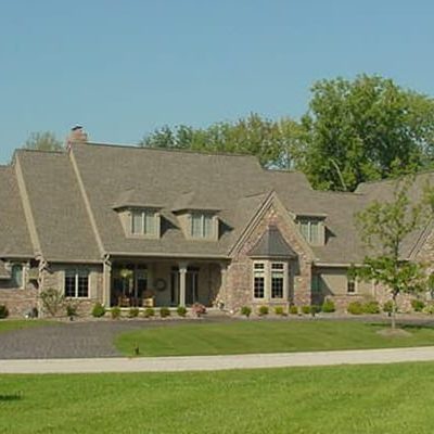Michael and associates two story home with manicured lawn and covered patio