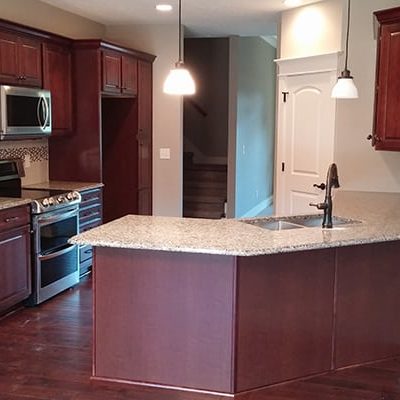 michael and associates custom home kitchen with cherry wood cabinets and white countertops