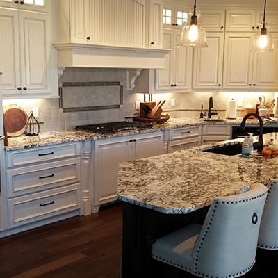 Michael and associated custom home kitchen with marble counter and white features